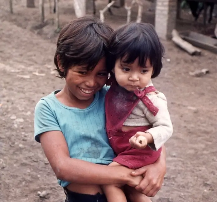 Grande et petite sœur — deux enfants souriants, photo d'époque